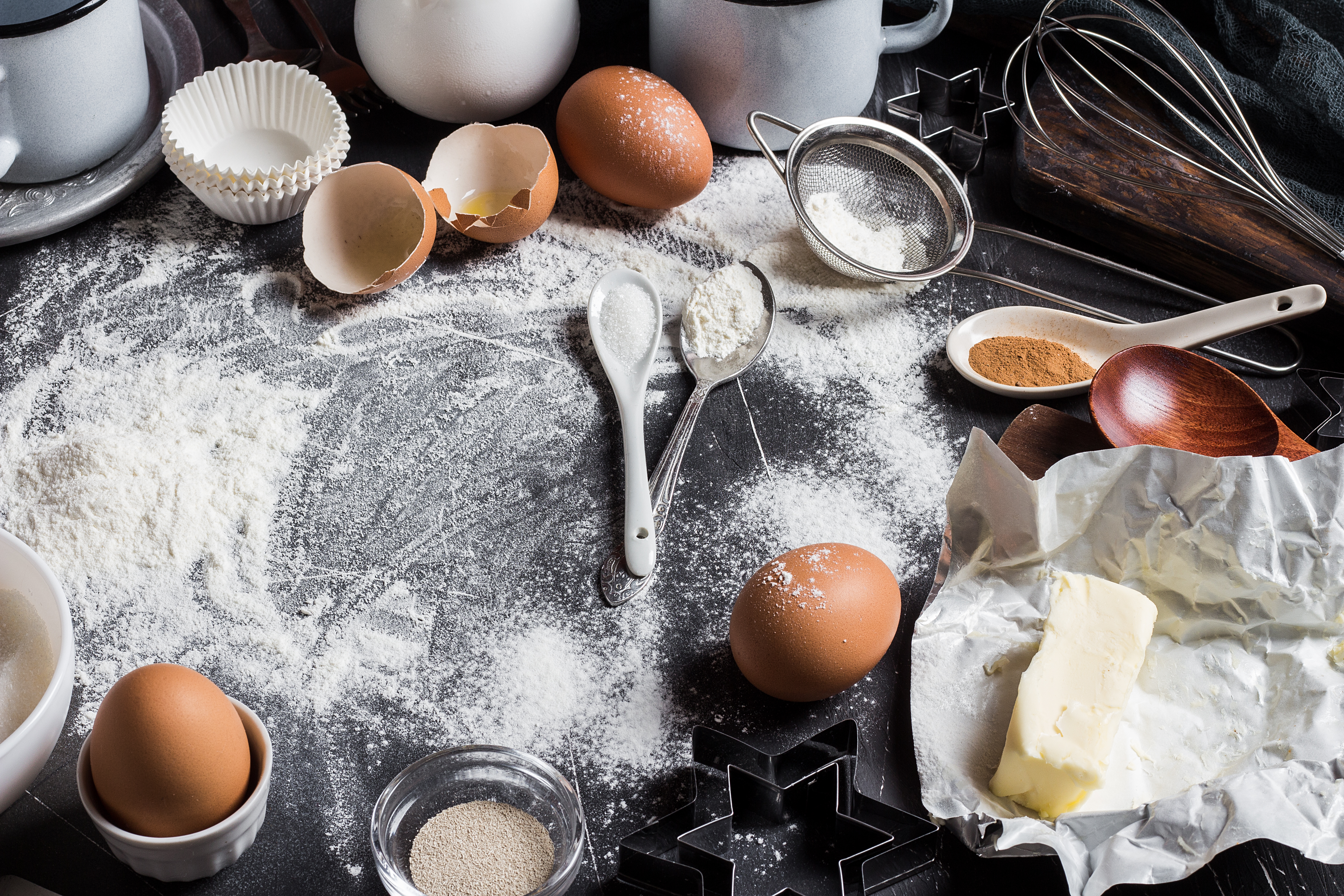 Préparation des ingrédients de cuisson pour la cuisine. Cadre accessoires d’épicerie maison pâtisserie oeufs farine sucre levure lait cuillère fouet pour la cuisson des aliments sur fond sombre avec espace de copie plat